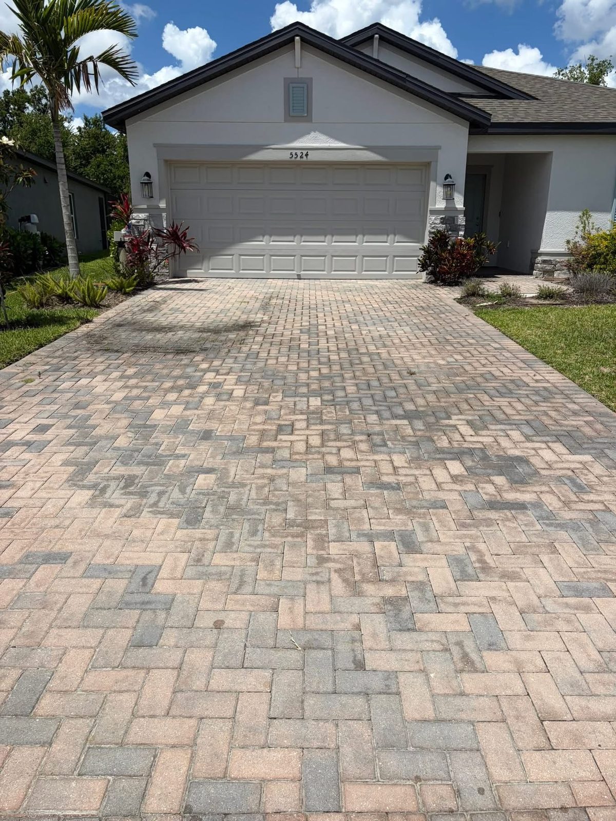 The same paver driveway before cleaning, faded and stained