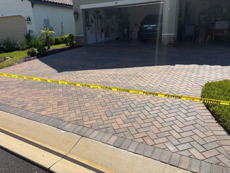 Freshly sealed paver driveway taped off to cure