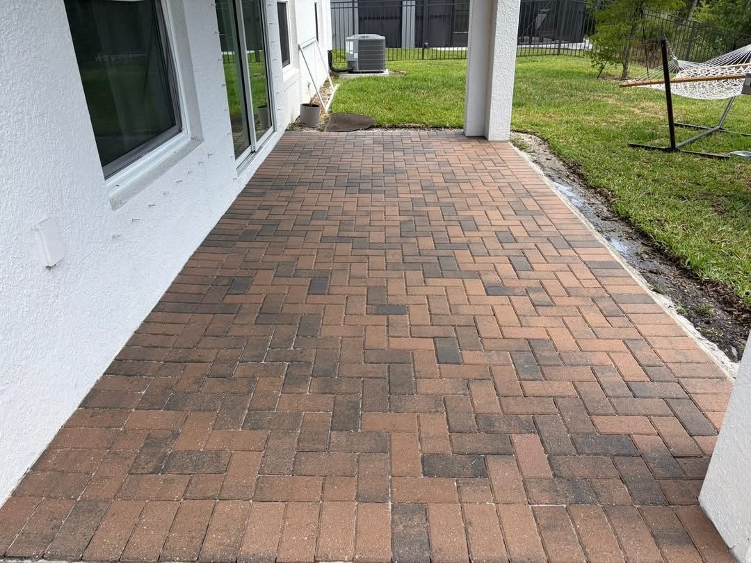 Screened lanai pavers after cleaning and sealing, rich red-brown finish